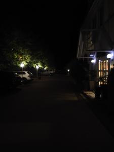 Een donkere straat 's nachts met auto's geparkeerd voor een gebouw. bij Genusshotel Rhönblick in Ostheim