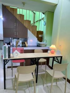 a kitchen with a table with chairs and a staircase at Bandung CoStay in Bandung