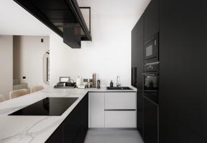 a black and white kitchen with white counters and appliances at Maison MUSA at Ca' Bela in Sala Comacina