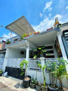 a white house with plants in front of it at Bandung CoStay in Bandung