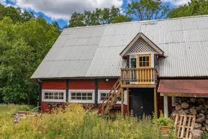 a red barn with a deck and a house at KRO845-Lessebo-Vedamala-14 in Ljuder