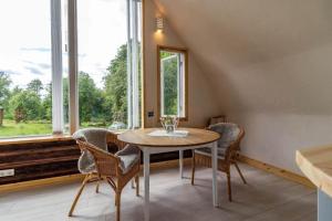 a dining room with a table and chairs and windows at KRO845-Lessebo-Vedamala-14 in Ljuder +17 photos