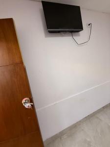 una tv su una parete bianca accanto a un muro di SGH Mathilu Rodadero a Santa Marta Altre 14 foto