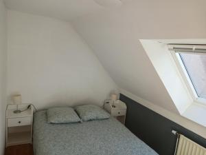 a small bedroom with a bed and a window at Résidences De Champles in Bierges