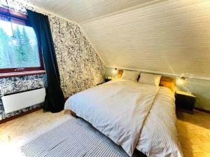 a bedroom with a large bed with a window at NOR118-Junosuando-Keraentoejaervi-81 in Junosuando