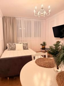 un soggiorno con un divano e due tavoli di ApAzory Kraków - przytulny apartament na wyłączność a Cracovia