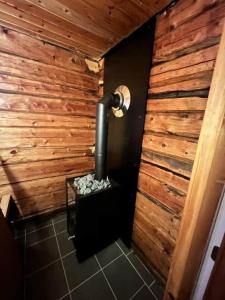 a bathroom with a wooden wall and a pipe at NOR118-Junosuando-Keraentoejaervi-81 in Junosuando