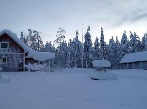 a barn with snow on the roof and benches in front at NOR118-Junosuando-Keraentoejaervi-81 in Junosuando +9 photos
