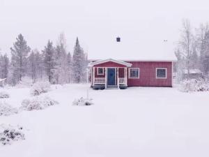 a small red house with snow on the ground at NOR118-Junosuando-Keraentoejaervi-81 in Junosuando