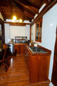 una cucina con mobili in legno e un forno a piano cottura di Solarium Cabaña a Riobamba