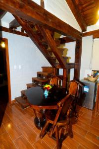 een tafel en stoelen in een kamer met een trap bij Solarium Cabaña in Riobamba