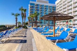 a row of chairs and umbrellas on a beach at Captain's Quarters Resort in Myrtle Beach