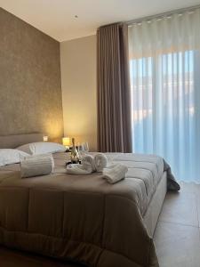 ein Schlafzimmer mit einem großen Bett mit einem großen Fenster in der Unterkunft 50 Passi dal Duomo in Marcianise