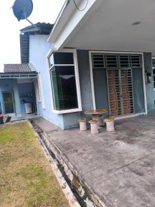 a house with a table and stools in front of it at Nani Homestay in Kampong Bukit Kuang