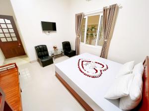 a bedroom with a white bed with a clock on it at Truong Ca Hotel in Phan Thiet