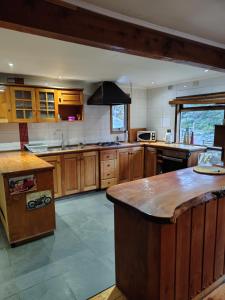 a large kitchen with wooden cabinets and a large island at Cabañas & Hostal Dos Rios in Malalcahuello