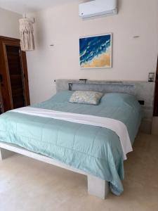 a bedroom with a bed with a green comforter at Nido 23 in San Benito +48 photos