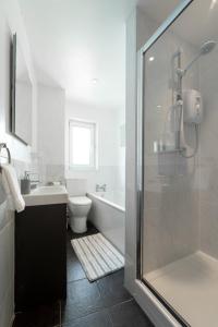 a bathroom with a shower and a toilet and a sink at Mayflower Penthouse in Dartmouth +35 photos