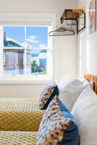 a bedroom with a bed with pillows and a window at Comfortable 2 Bed Airdrie Flat w Private Parking in Airdrie