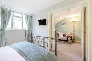 a bedroom with a bed and a living room at Mayflower Penthouse in Dartmouth