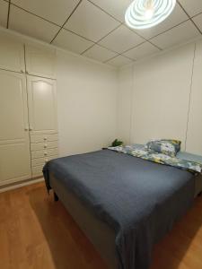 een slaapkamer met een bed en een kast en een plafond bij Simple Cozy House in Raahe