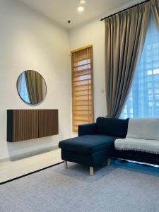 a living room with a blue couch and a mirror at Che Nat Che Nor Homestay in Kuala Terengganu