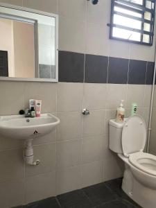 a bathroom with a sink and a toilet and a mirror at Che Nat Che Nor Homestay in Kuala Terengganu +26 photos