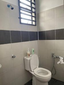 a bathroom with a white toilet and a window at Che Nat Che Nor Homestay in Kuala Terengganu