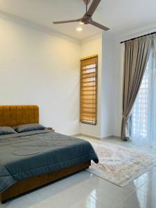 a bedroom with a bed and a ceiling fan at Che Nat Che Nor Homestay in Kuala Terengganu