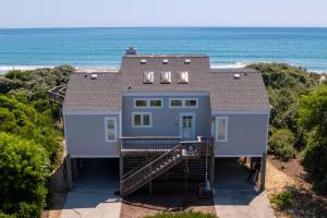 a house on the beach with the ocean in the background at 1222 - Asher in Corolla +48 photos