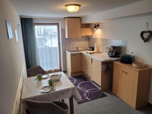 a small kitchen with a small table and a table and a tableablish at Haus Steinacher in Hopferau