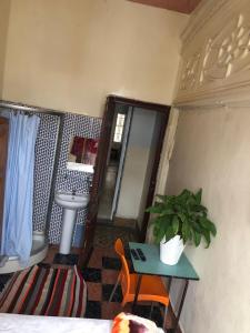 a bathroom with a sink and a table with a plant at Pension Gibraltar in Tangier