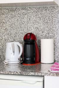 a red toaster sitting on a counter next to a toaster at Apartamentos Océanos in Málaga