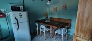 a small kitchen with a table and a refrigerator at "Donde brilla el sol" Casa Campo in Dina Huapi