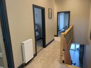 a hallway with two doors and a staircase with a mirror at Spring Meadow in Durham