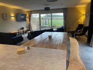 a living room with a wooden table and a large window at Spring Meadow in Durham