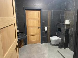 a bathroom with a toilet and a sink and a door at Spring Meadow in Durham
