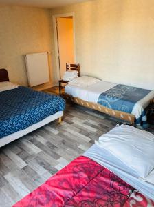 una stanza con tre letti in una stanza di Le relais de la providence a Suèvres
