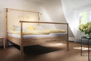 a bed with a wooden frame in a room at Kaštieľ Čičmany in Čičmany +34 photos