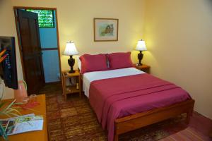 a bedroom with a bed with red pillows at Coral House Inn in Punta Gorda