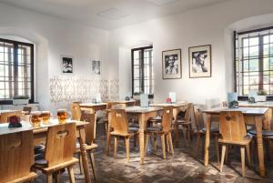 a dining room with wooden tables and chairs at Kaštieľ Čičmany in Čičmany