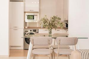 une cuisine avec une table, des chaises et un vase de fleurs dans l'établissement Alojamientos Estrella Baeza, à Baeza