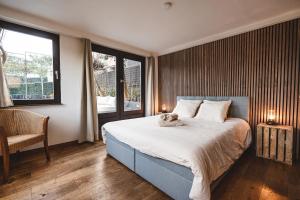 een slaapkamer met een bed met een knuffeldier erop bij Twin Pines in Durbuy