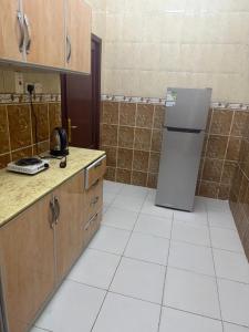 una cucina con frigorifero e pavimenti in piastrelle bianche di منار الوجه a Al Wajh