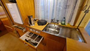 een kleine keuken met een wastafel en een raam bij Erlebe unseren Verein im geräumigen Wohnwagen! in Feldkirchen bei Graz