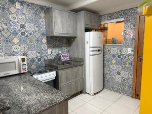 een keuken met een koelkast en een magnetron bij Mariscal 2 quartos 3 banheiros -SOBRADO AMENDOEIRA in Bombinhas +53 foto's