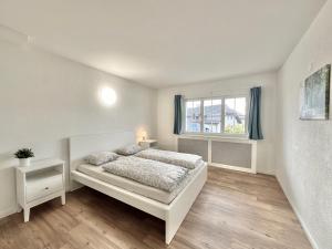 een witte slaapkamer met een bed en een raam bij Furnished Living Room in Günsberg Solothurn in Günsberg  