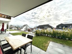 een patio met een tafel en stoelen en uitzicht op een tuin bij Furnished Living Room in Günsberg Solothurn in Günsberg  