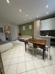 una cucina e un soggiorno con un tavolo e un divano di LA TANA Guest House a Dronero