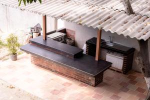 une cuisine extérieure avec un grill sous une pergola dans l'établissement Cabaña Casa Lila, à Santa Marta